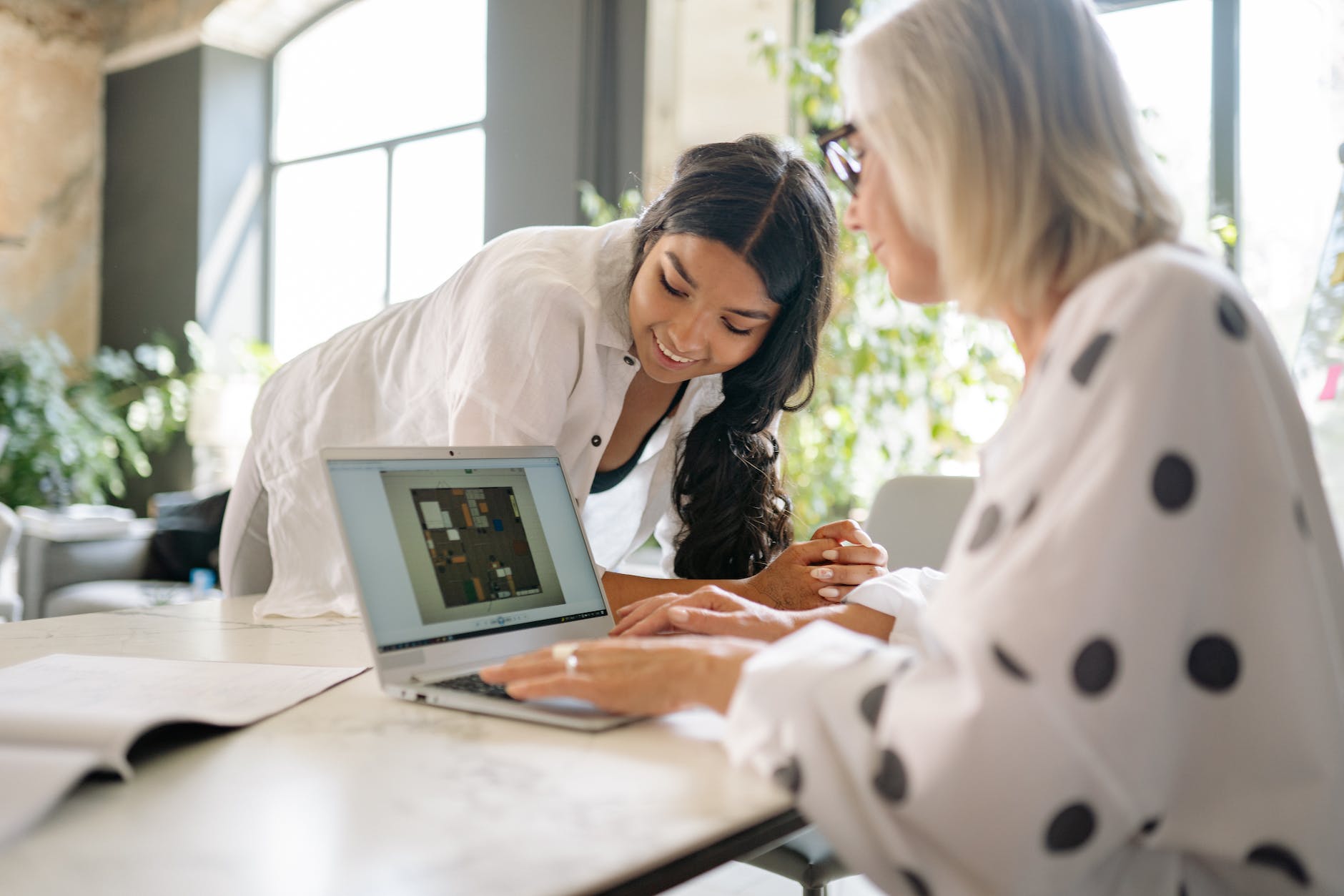employees looking at the floor plan on the monitor of a laptop
