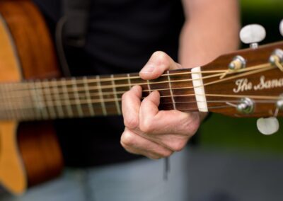 Close up of a man playing a guitar. Event photography Northern Ireland